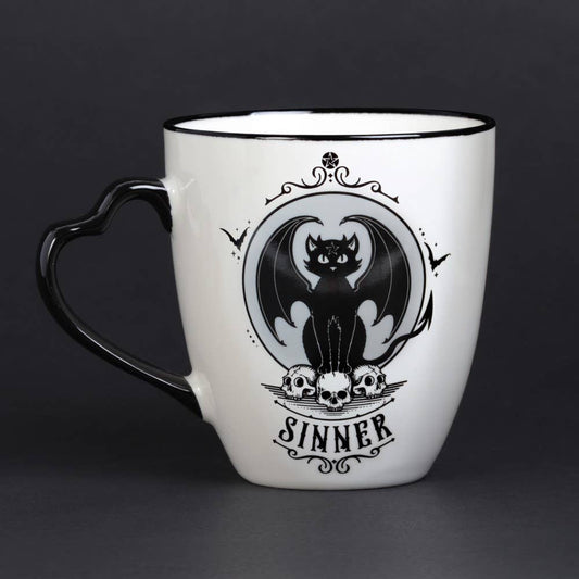 White mug with black handle featuring a bat and skull design on a dark background