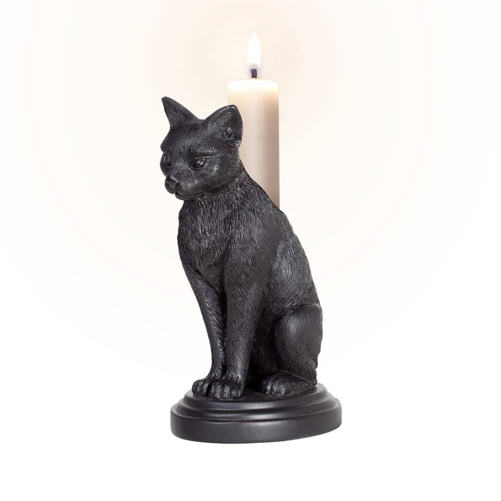 Black cat-shaped candle holder with a lit candle on a white background