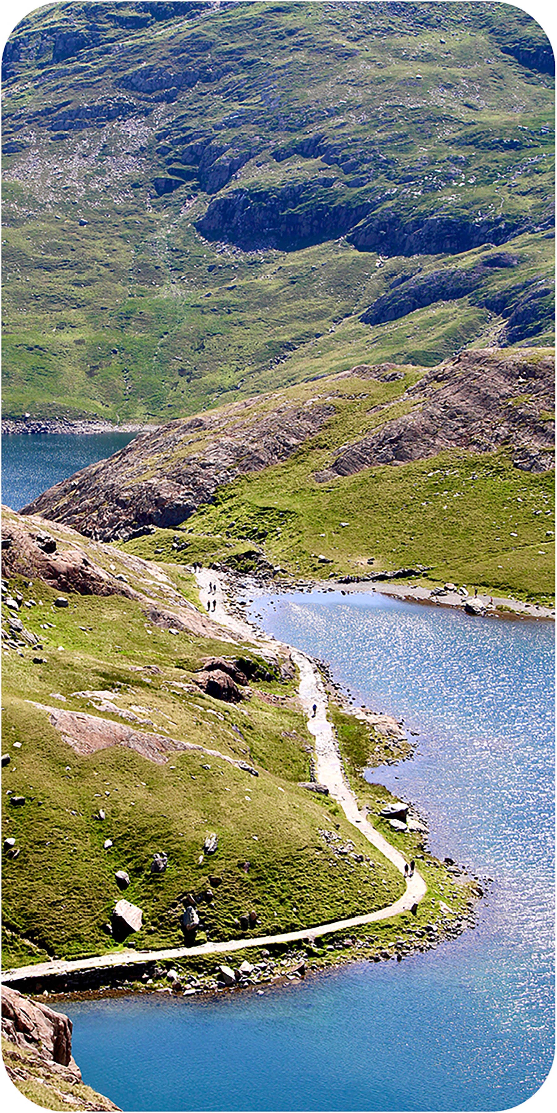 Scenic view of a lake surrounded by green hills