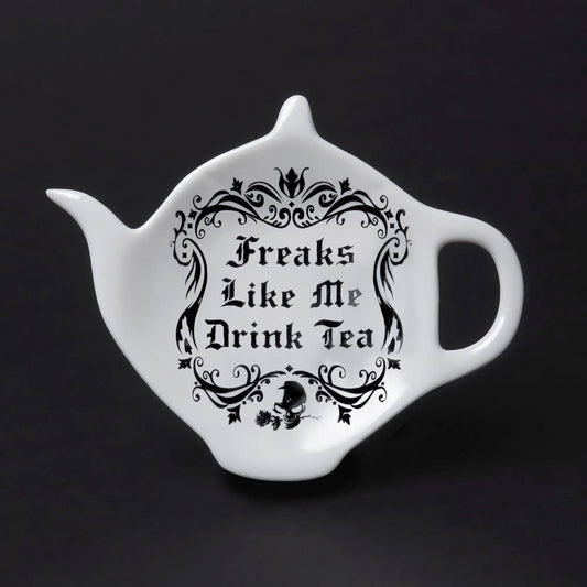 White teapot-shaped mug with black text and decorative elements on a black background