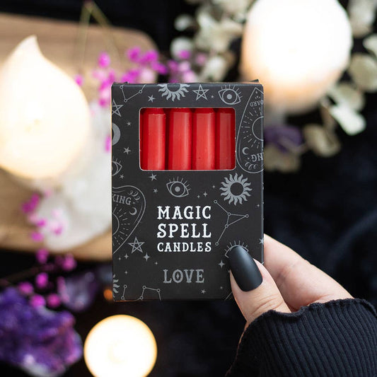 Box of 'Magic Spell Candles Love' with red candles inside, held by a hand against a mystical background.