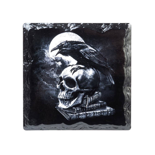 Decorative slate with a skull, book, and crow design against a dark background.