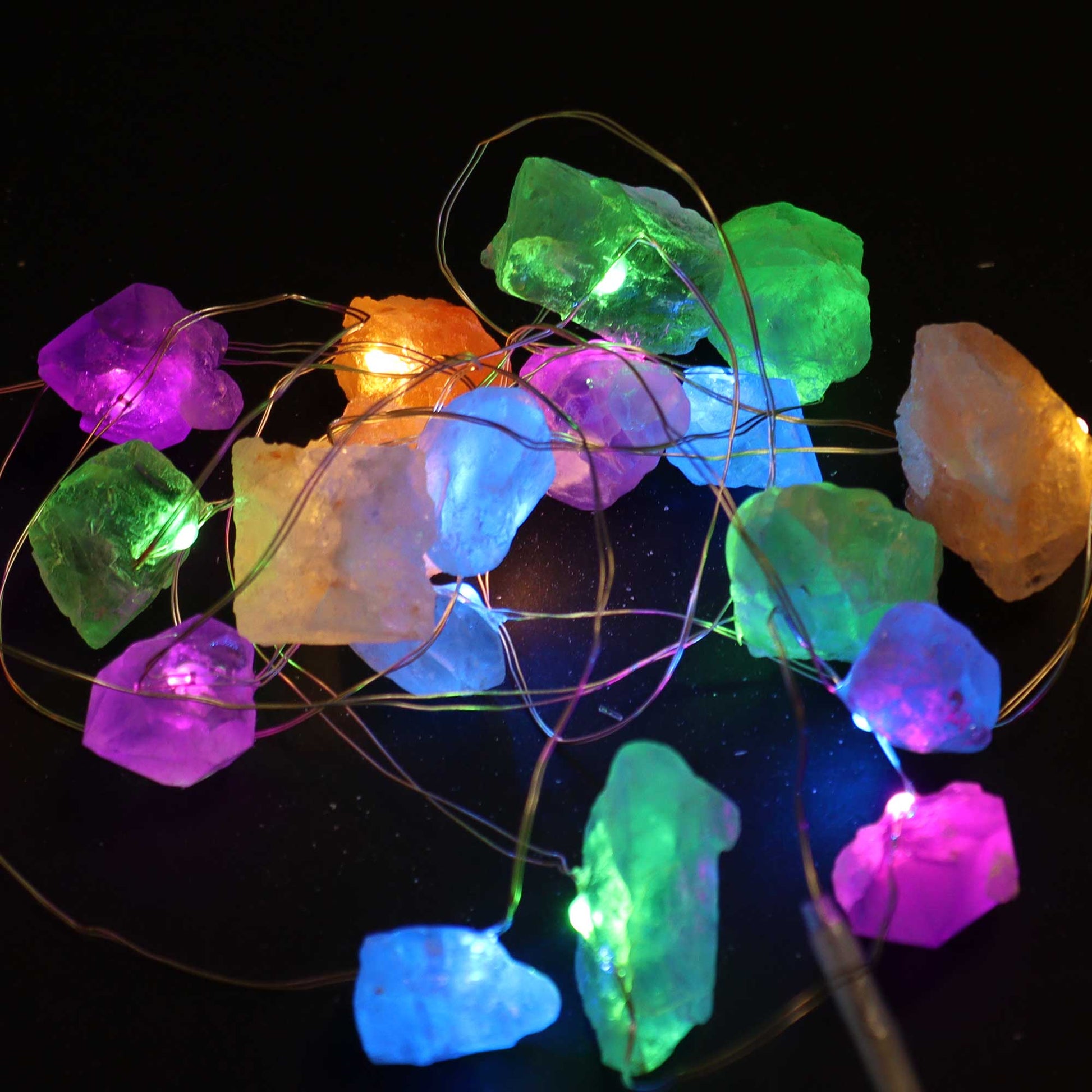 Multi-coloured gemstone lights lit up on a black background