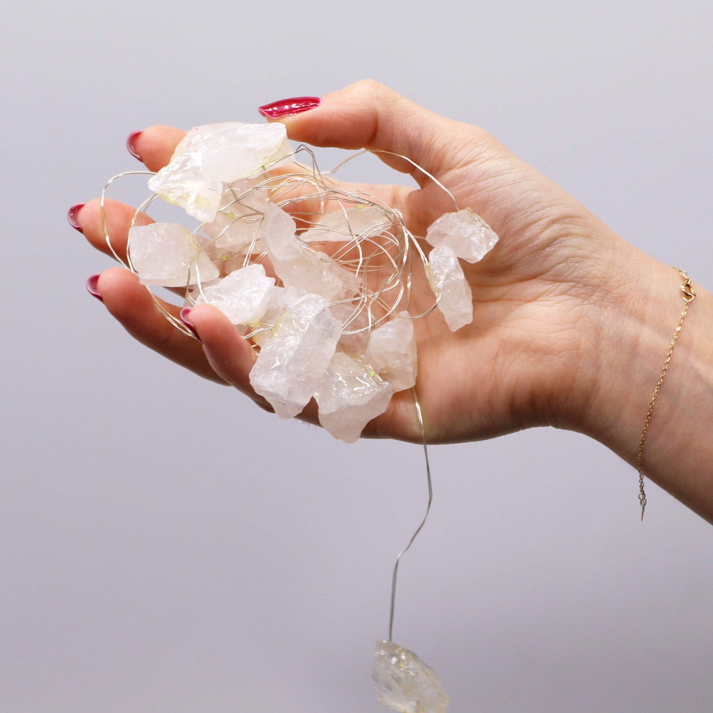 Rock quartz gemstone lights being held in palm of hand