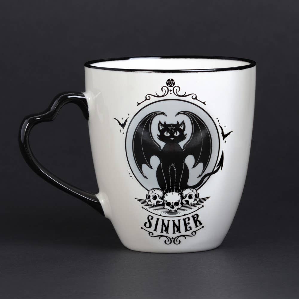 White mug with black handle featuring a bat and skull design on a dark background