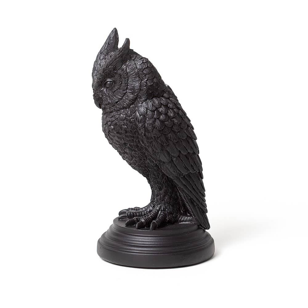Black owl statue on a white background