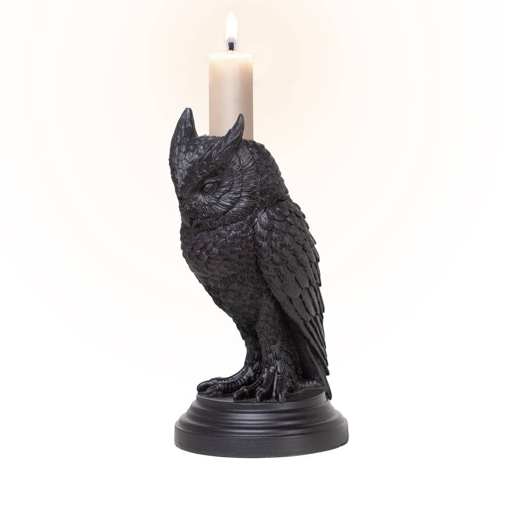 Black owl candle holder with a candle on a white background
