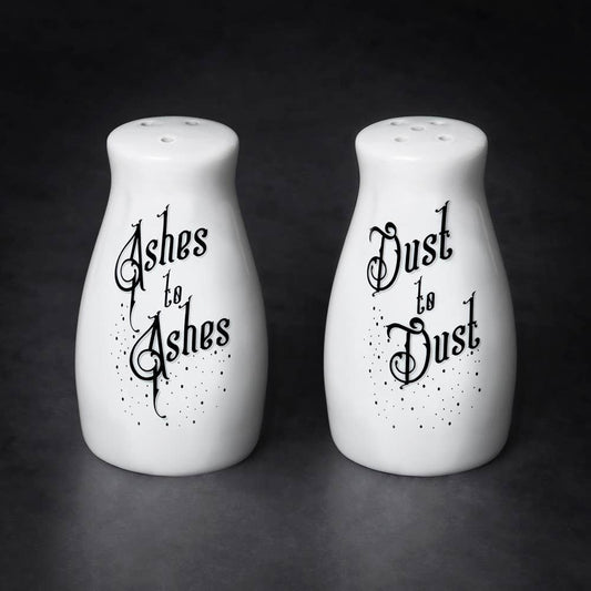 Two white salt and pepper shakers with black text on a dark background