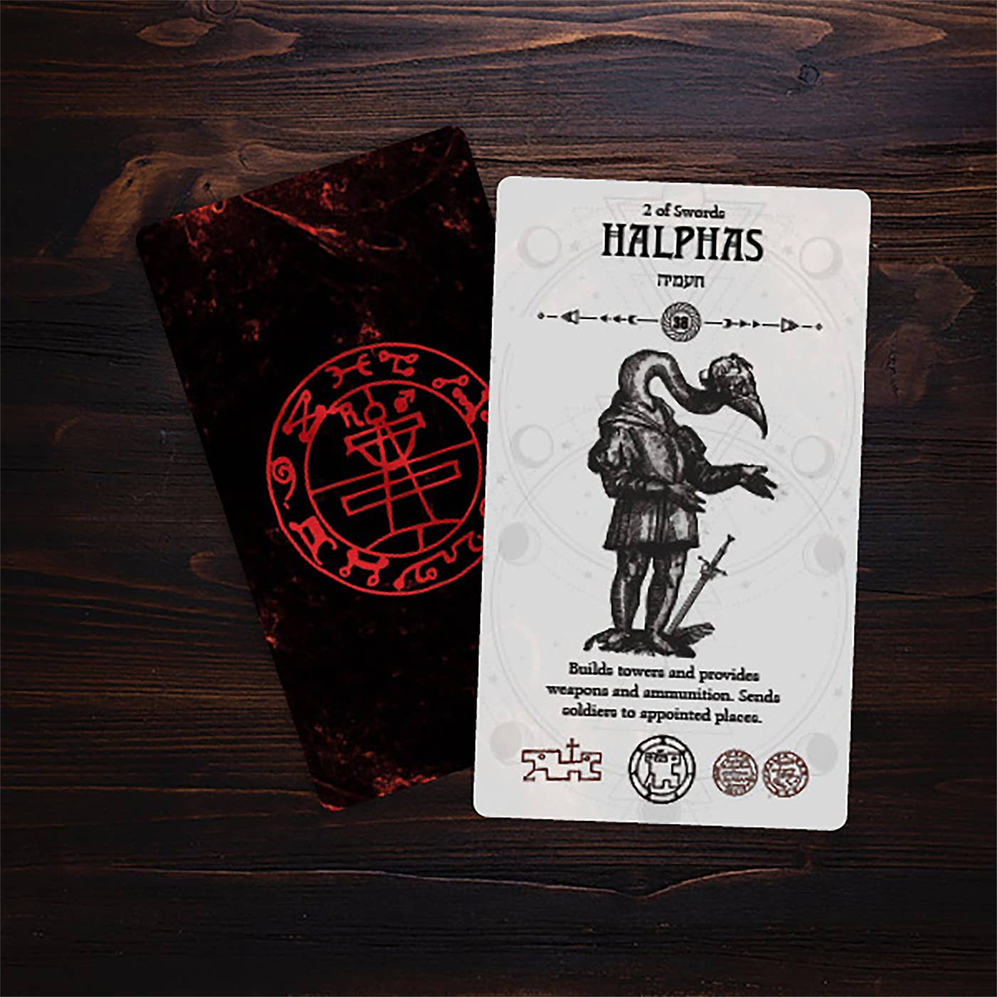 Tarot card featuring a character with a sword and text on a wooden surface with a dark red cloth.