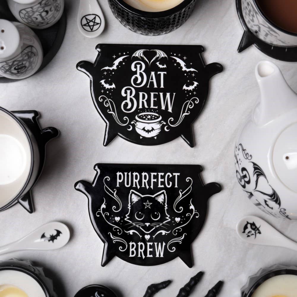 Two black and white decorative coasters with 'Bat Brew' and 'Purrfect Brew' text on a marble surface.