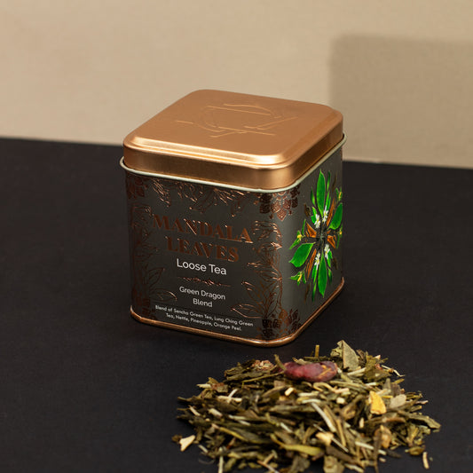Mandala leaves loose tea, green dragon blend, displayed with gold and black tin