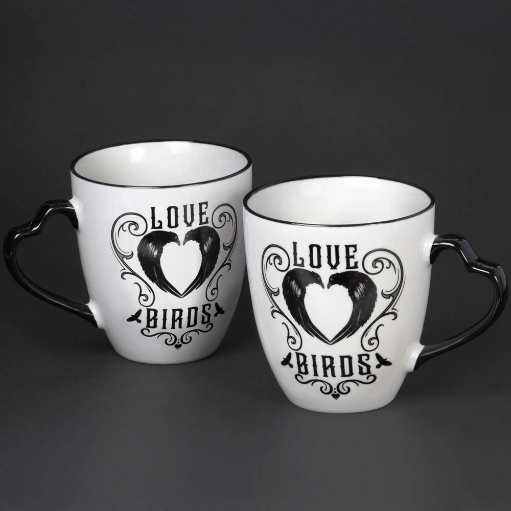 Two white mugs with black heart design and 'Love Birds' text on a dark background