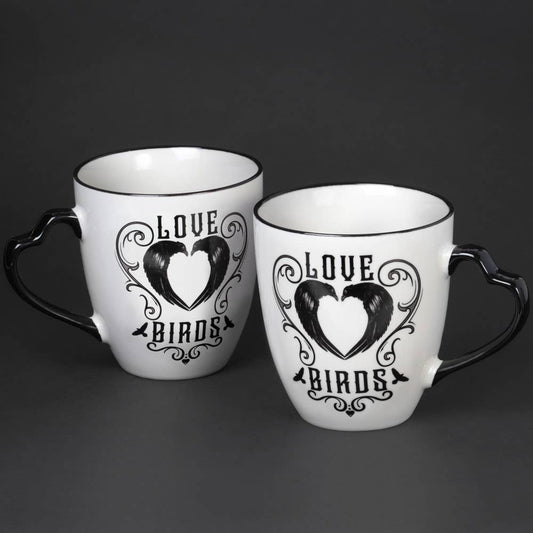 Two white mugs with black heart design and 'Love Birds' text on a dark background