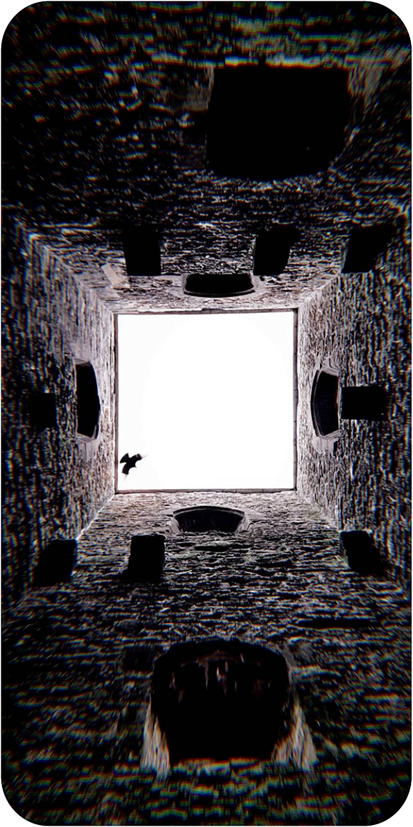 Dark, textured interior space with a bright light source at the center