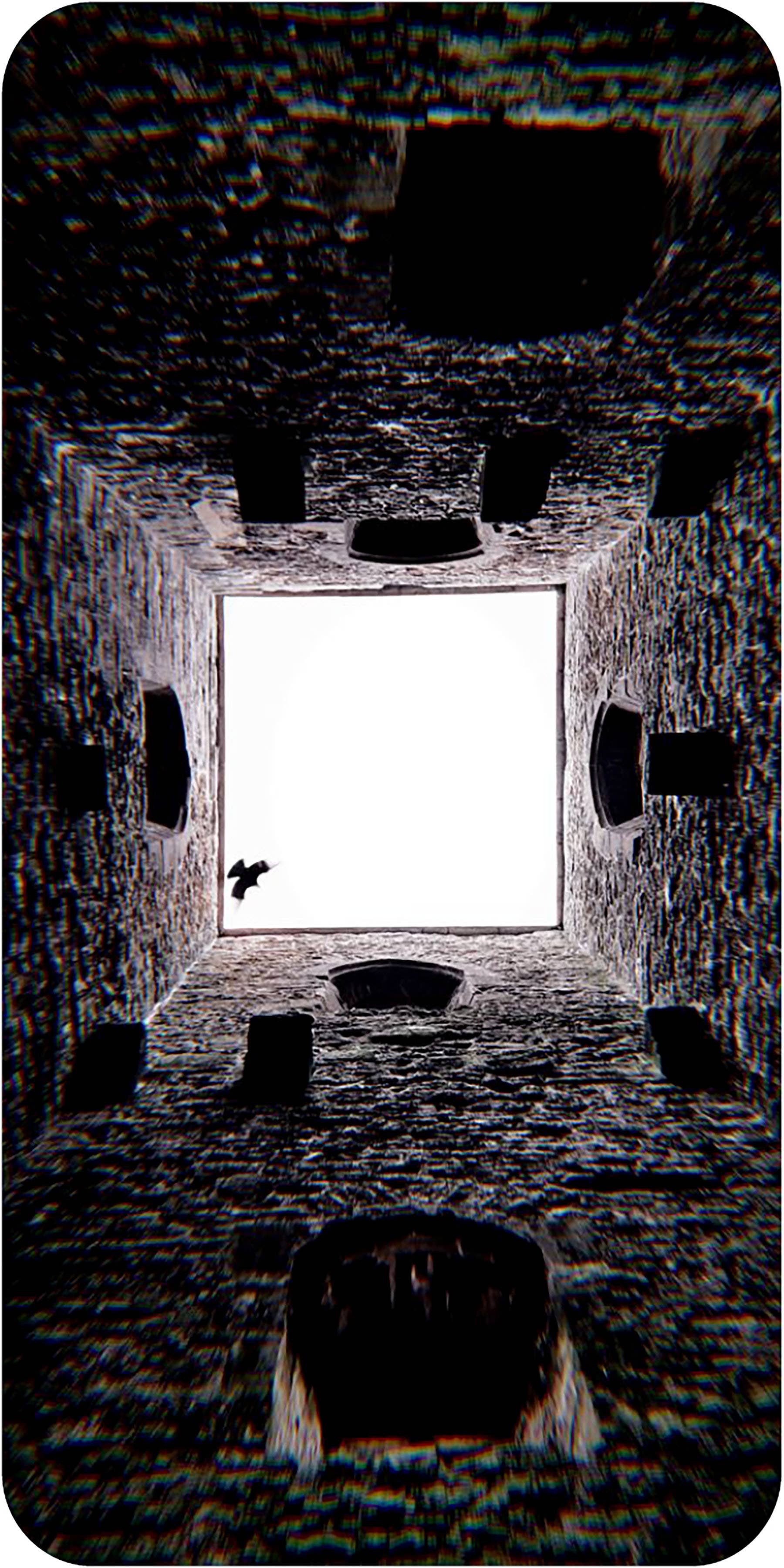 Dark, textured interior space with a bright light source at the center