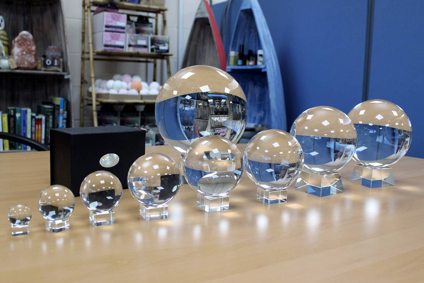 Set of crystal balls on a wooden surface with a bookshelf and blue wall in the background