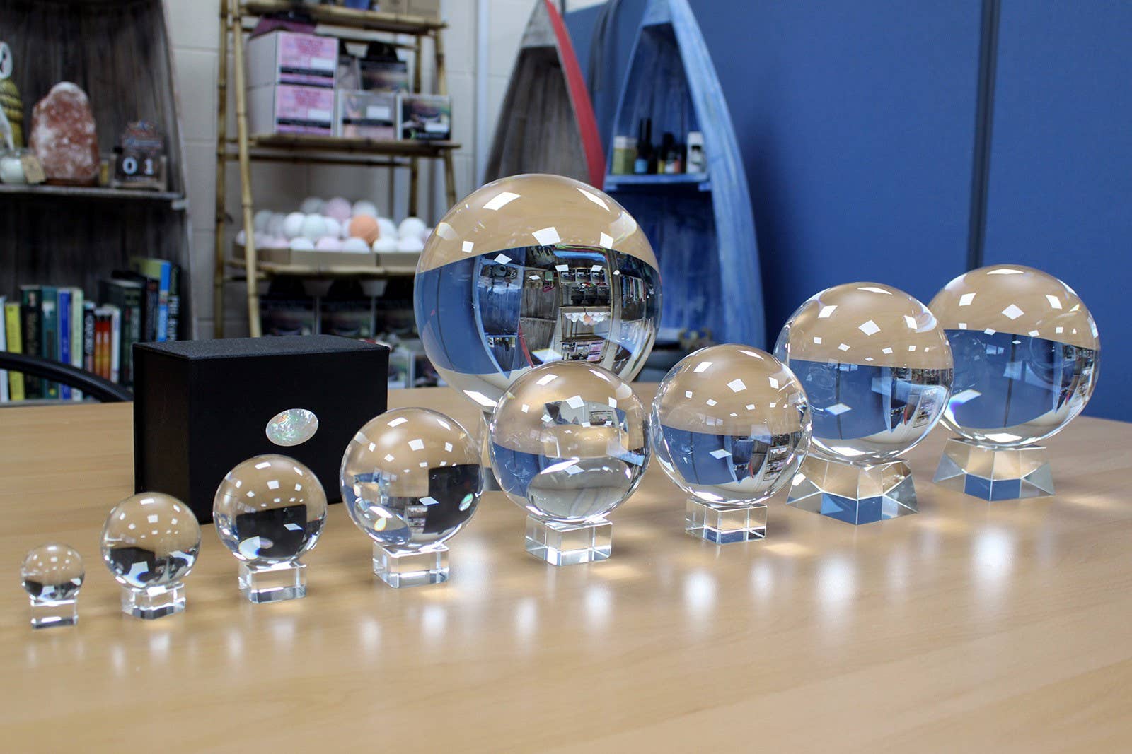 Set of crystal balls on a wooden surface with a bookshelf and blue wall in the background