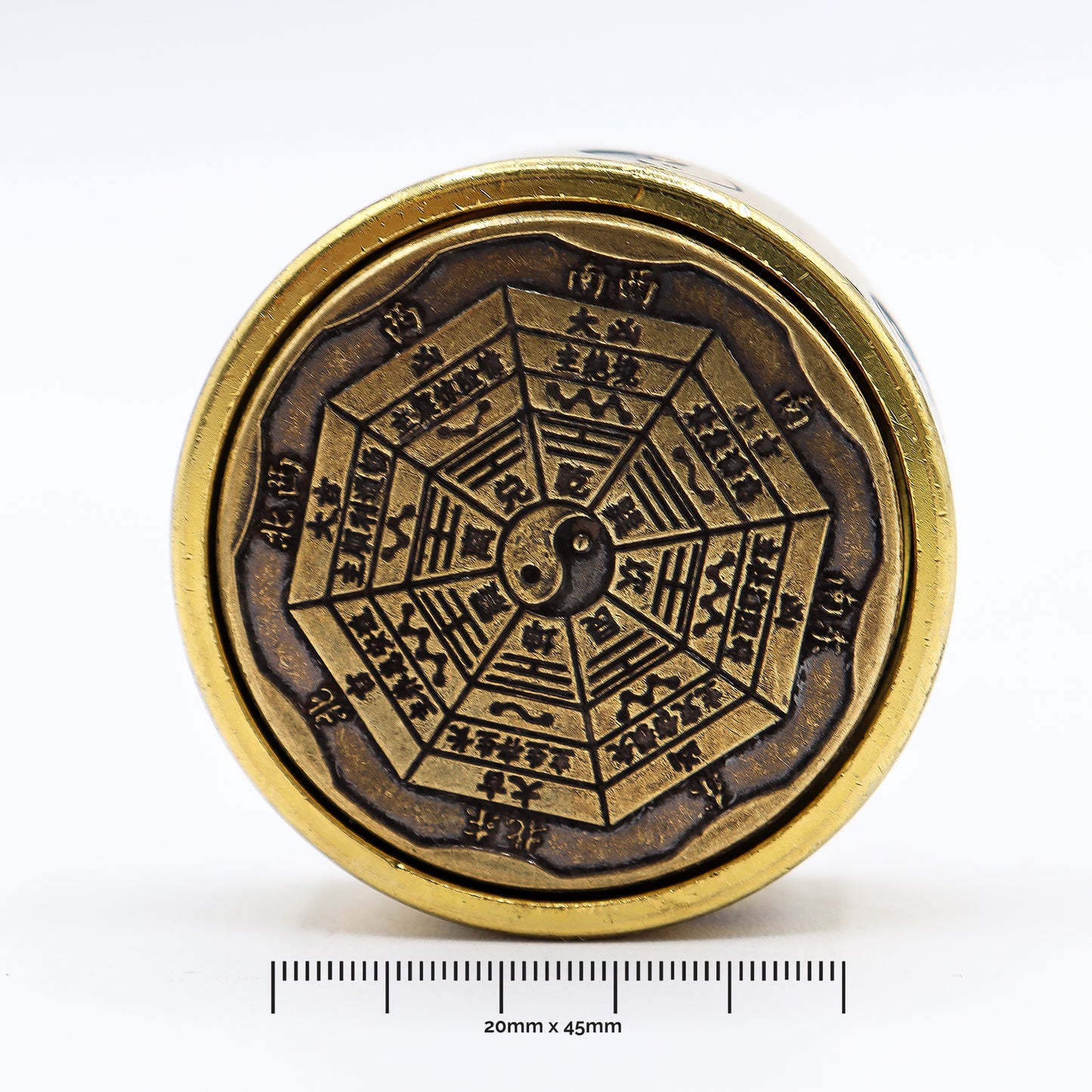 Bronze compass with intricate design and measurements on a white background