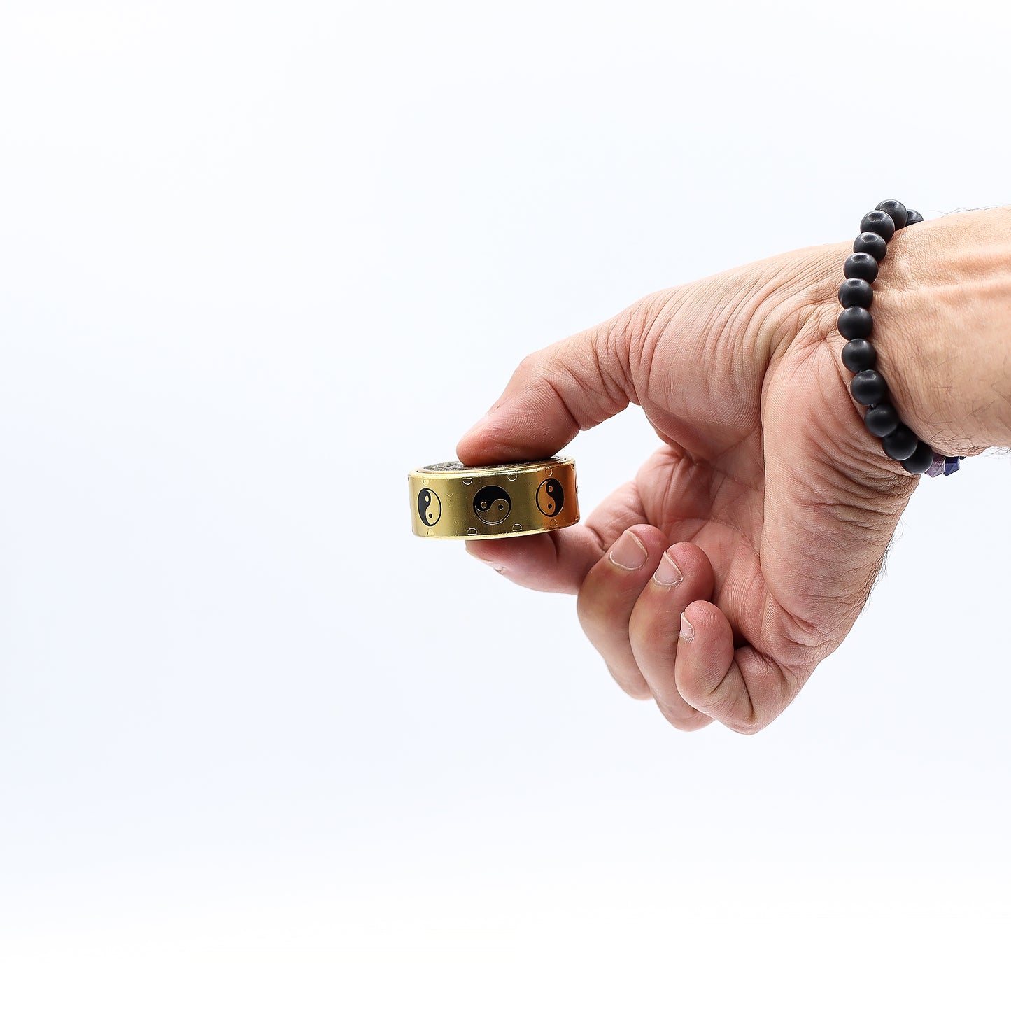 Hand holding a gold ring with a white background