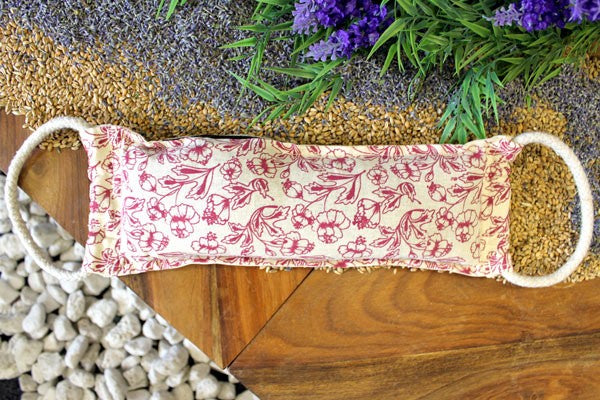 Floral-patterned pillow on a wooden surface with lavender and greenery